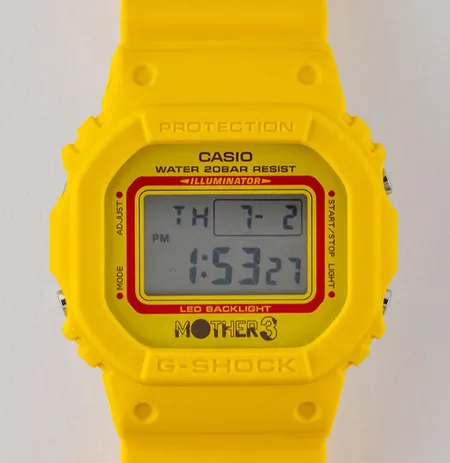 Tampak depan Casio G-Shock DW-5600MOT26-9 dengan aksen merah dan logo Mother 3